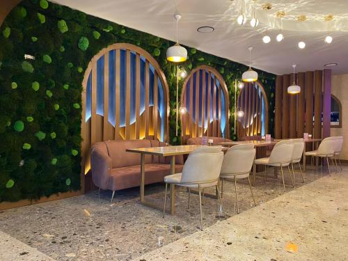 特拉布宗Gloria Suite Hotel的一间带桌椅和绿色墙壁的餐厅