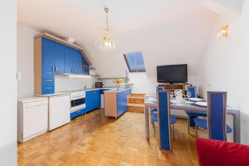 斯洛文尼亚格拉代茨Apartma Lea的厨房配有蓝色橱柜和桌椅