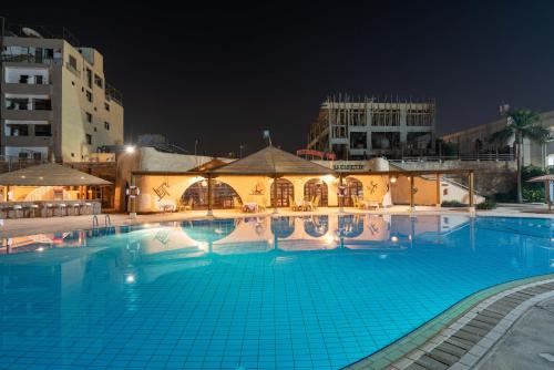 卢克索Aracan Eatabe Luxor Hotel的一座拥有大楼的大型游泳池