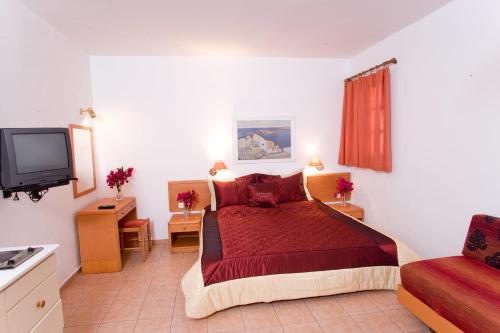 林都斯林都斯阿纳斯塔西娅一室公寓的一间卧室配有红色的床和电视