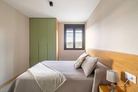巴尔多维尼奥APARTAMENTOS LAS OLAS BY PANTIN的一间卧室设有一张大床和窗户
