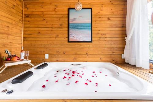 因比图巴Casa com Banheira, Piscina e Quadra de Areia的浴缸里装满红色玫瑰花瓣