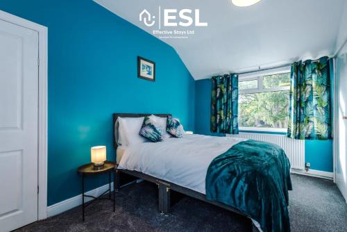 切斯特3 Bedroom House with Garden and Driveway Parking - 7 Mins from Chester City Centre的蓝色的卧室设有床和窗户