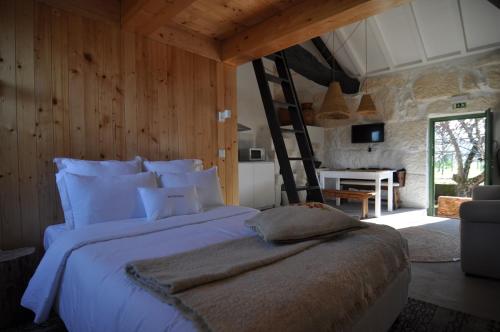 阿马兰特Quinta do Santinho的卧室配有一张带梯子的白色大床