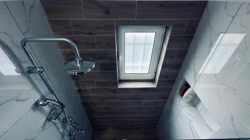马科普隆Hodos Luxury APT near ATH-Airport的带淋浴的浴室和窗户。