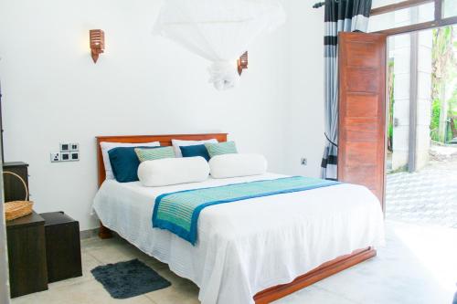 本托塔Villa Freiheit Himmel的白色卧室配有蓝色枕头的床
