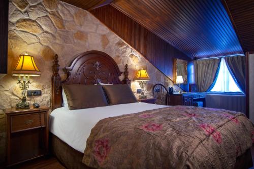 美特索文卡萨罗斯酒店的一间卧室设有一张带石墙的大床