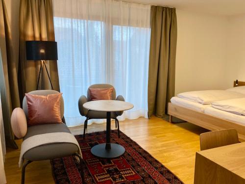 巴特恩多夫Birkenhof Apartments的酒店客房带一张床、一张桌子和椅子