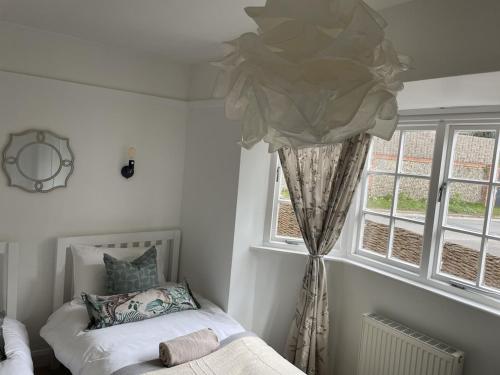 绍斯沃尔德Cottage Number 5 in Southwold - Charming cottage gardens的一间卧室设有一张床和一个窗口