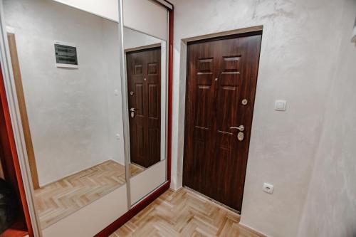阿然德洛维克Apartman Marimark deluxe的走廊设有两扇木门和镜子