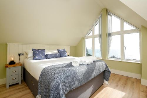 波尔佩罗Fishermans Heights的一间卧室配有一张带蓝色枕头的床和一扇窗户。