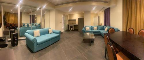 杜拉特阿拉尔Bana Bana Resort的大型客厅配有蓝色的沙发和桌子