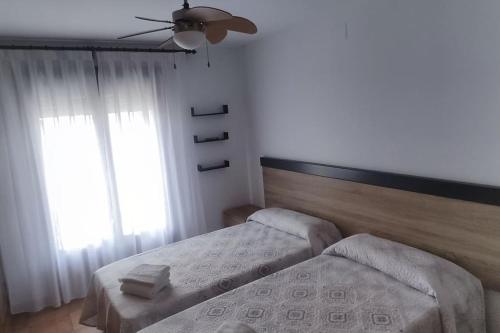 埃尔阿雷纳尔El casillo的一间卧室配有两张床和吊扇