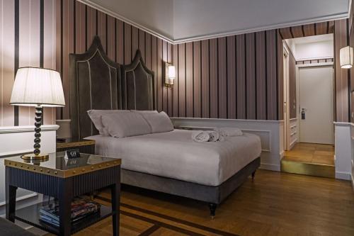 罗马Il Campo Marzio的一间卧室配有一张床和一张带台灯的桌子