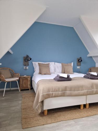 佐特兰德Beachhouse Zeewinde的一间卧室设有一张蓝色墙壁的大床
