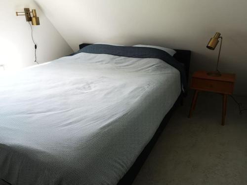 内斯Lanterfant的卧室配有白色的床和床头柜