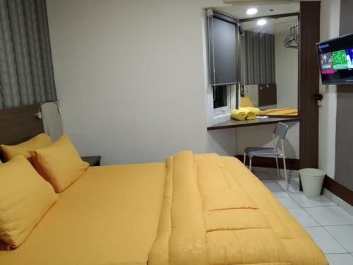 当格浪SMART Dream Inn的一间卧室配有一张黄色的大床和一台电视