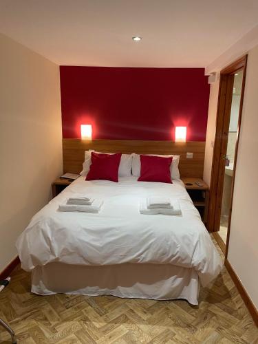 斯特利特The King Alfred的卧室配有一张白色大床和红色的墙壁