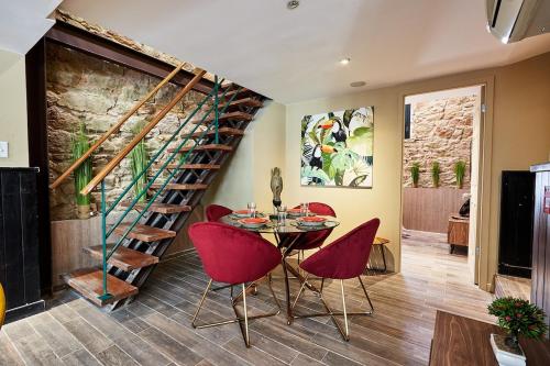 巴拿马城AmazINN Places Rooftop and Design Pool X的一间带桌子和红色椅子的用餐室以及螺旋楼梯