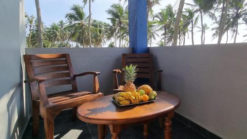 瓦都瓦Dhammika Beach Palace的桌上一碗水果和两把椅子