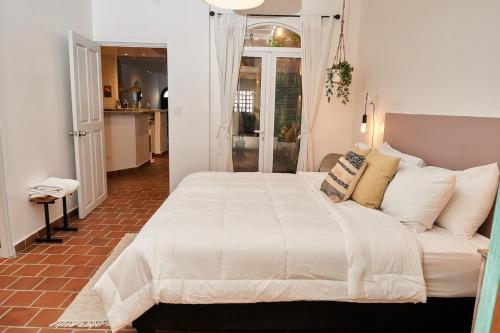 巴拿马城AmazINN Places Casco Viejo Casa Espanola的卧室配有一张带白色床单和枕头的大床。