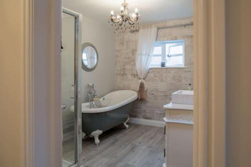 图克斯伯里Charming 2 Bed House in Tewkesbury Centre的带浴缸、水槽和镜子的浴室