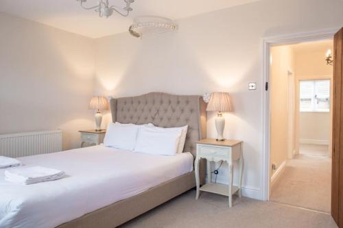 图克斯伯里Charming 2 Bed House in Tewkesbury Centre的一间卧室配有一张带两盏灯的大型白色床。