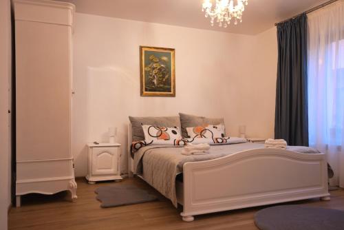 雅西casa Flav的卧室配有白色的床和吊灯。