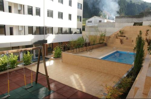 比韦罗Apartamento Piscina 1G by Urraca Suites Viveiro的一座建筑旁的一座建筑,设有游泳池