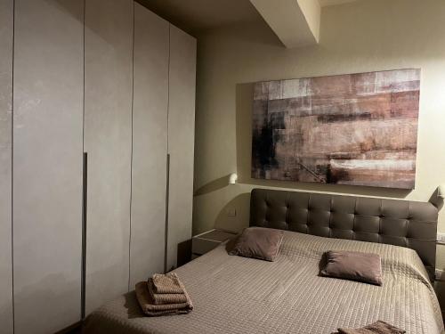 帕尔马Maison del Ducato Cavour 37的卧室配有一张床,墙上挂有绘画作品
