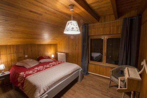 克松吕-隆日梅La Ferme des 3 lacs的木制客房内的一间卧室,配有一张床