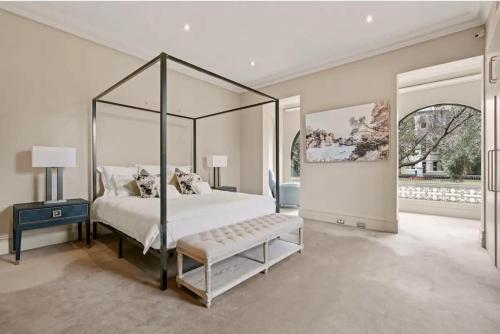 悉尼The Kirribilli的一间卧室配有一张天蓬床,内设长凳