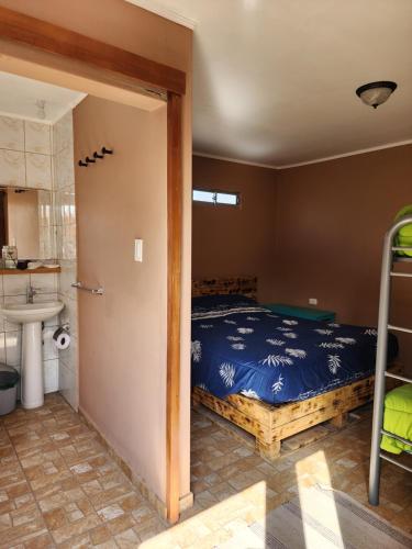 圣佩德罗·德·阿塔卡马Las Casas Hostel Atacama的一间卧室配有一张床,浴室设有水槽