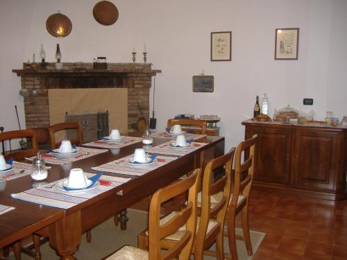 PegognagaAgriturismo Cà Rossa的一间带长桌和壁炉的用餐室