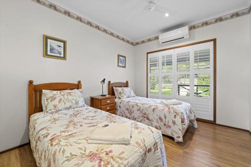 云加布拉小鸟鲜花度假屋的一间卧室设有两张床和窗户。