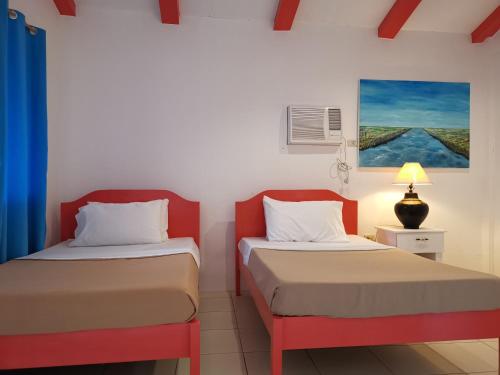 萨马尔La Vida Hostel Samal Island的一间设有两张床和一盏灯的房间