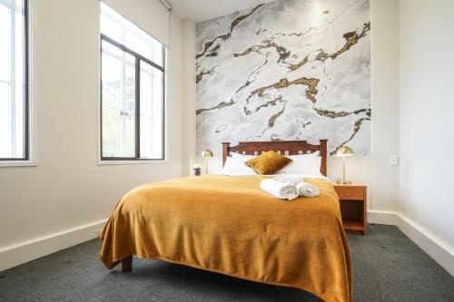 因弗卡吉尔Tuatara Lodge的一间卧室配有一张大床和毛巾