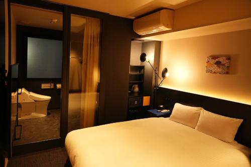东京东京东神田秋叶原N+酒店的酒店客房,配有床和电视