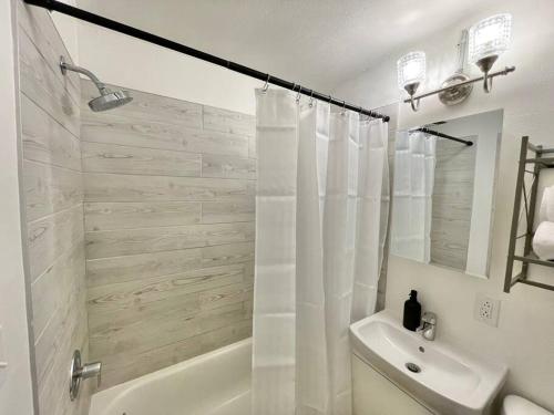 匹兹堡The Clemente Mt. Washington by Luxe PGH的白色的浴室设有淋浴、浴缸和水槽。