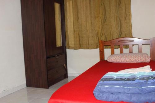 麻坡Homestay Mokde的一间卧室配有红色的床和梳妆台