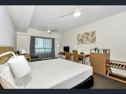 达尔文Executive Studio Darwin CBD (Water Views)的卧室配有一张白色大床和一张书桌