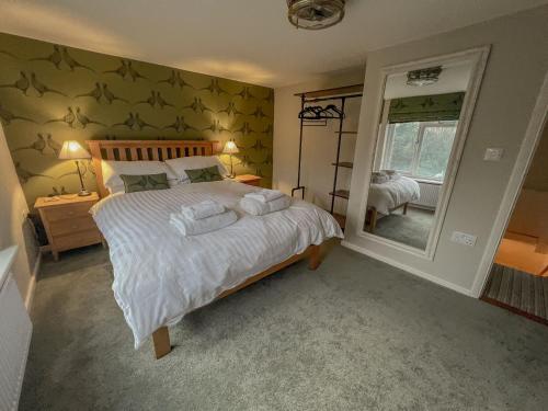 AldringhamKnodishall - Newly renovated 2 bed holiday home, near Aldeburgh, Leiston and Thorpeness的一间卧室配有一张大床和镜子