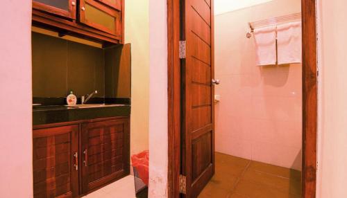 勒吉安Kuta Paradise 777的一间带水槽和淋浴的浴室以及一扇门