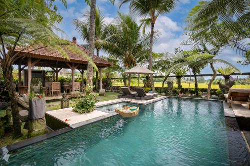乌布Prabhu Ubud Villa的棕榈树度假村内的游泳池