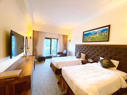河江Phoenix Hotel Hà Giang的酒店客房配有两张床和一张书桌