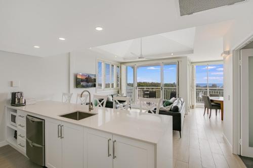 金斯克里福2BR Oceanview Penthouse @ Mantra Salt Resort by uHoliday的开放式厨房以及带桌椅的客厅。