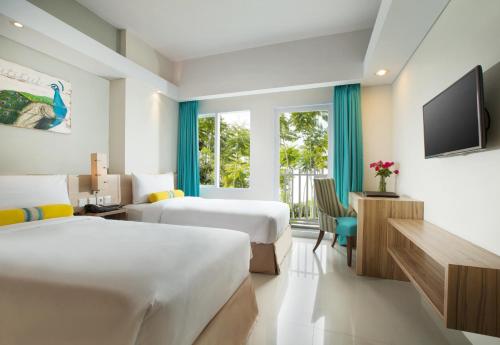茂物Swiss-Belcourt Bogor的酒店客房设有两张床和电视。