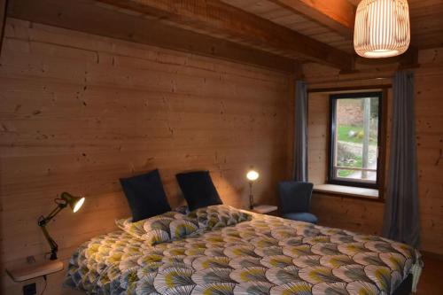 RochessonA la cheneau的一间卧室配有一张带两把椅子的床和一扇窗户
