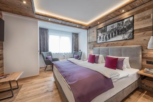 巴特霍夫加施泰因Apartment NH96 inklusive kostenfreiem Eintritt in die Alpentherme的一间卧室设有一张大床和木墙