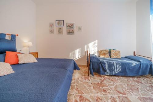 马尔恰纳Casavacanze delle Noci的一间卧室配有两张蓝色的床和椅子